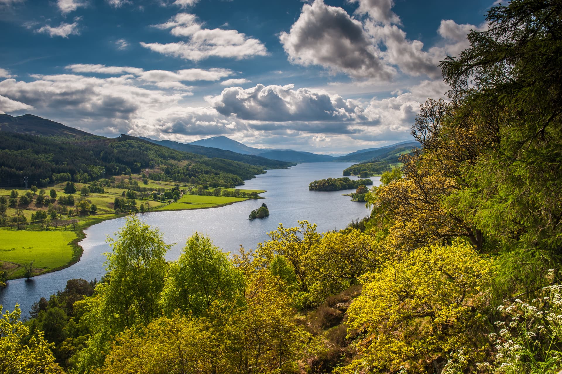 Loch Tummel near Pitlochry with islands, green hills, and dramatic clouds.