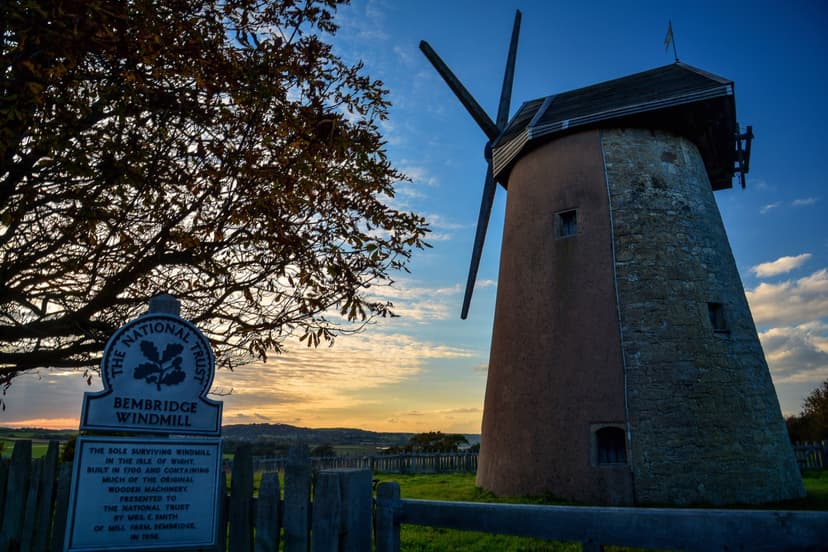 Bembridge Windmill on the Isle of Wight at sunset with informative sign in foreground
