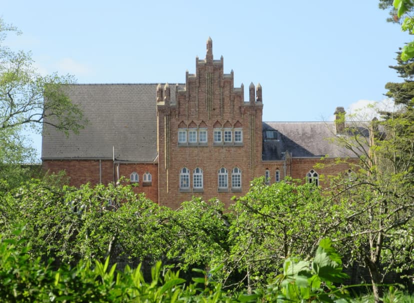 Quarr Abbey red brick building behind green trees on the Isle of Wight